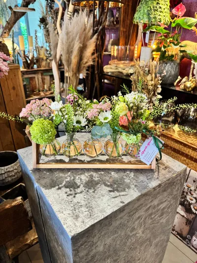 Holzgestell mit Glasvasen und Wiesenblumen